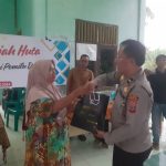 KBO Sat Resnarkoba Polres Tapsel, Ipda TP Saragih, saat menyerahkan souvenir kepada perwakilan masyarakat di sela gerakan Kapolres Jelajah Huta di Kabupaten Padang Lawas Utara