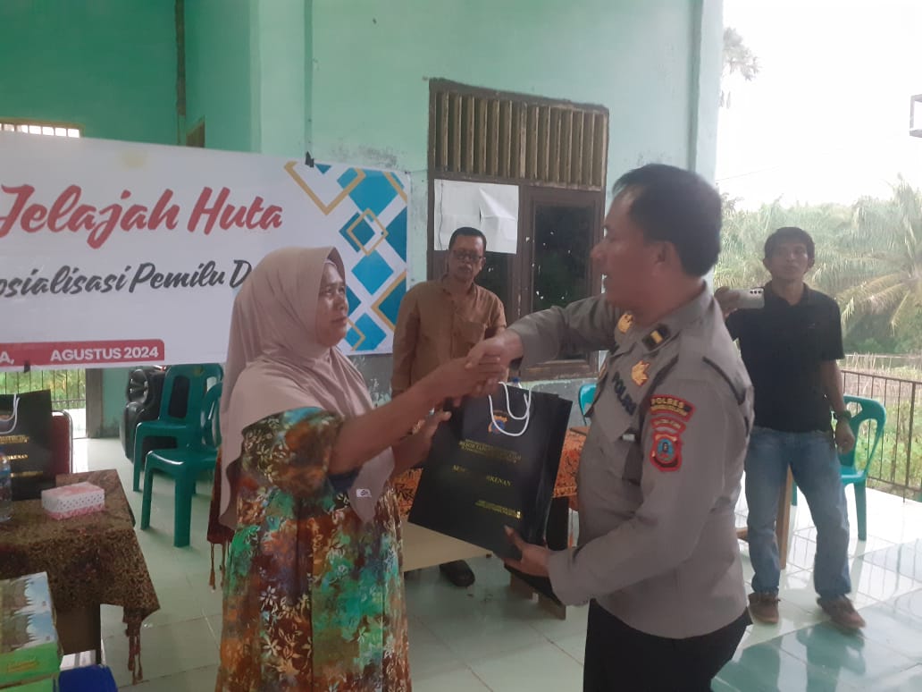 KBO Sat Resnarkoba Polres Tapsel, Ipda TP Saragih, saat menyerahkan souvenir kepada perwakilan masyarakat di sela gerakan Kapolres Jelajah Huta di Kabupaten Padang Lawas Utara