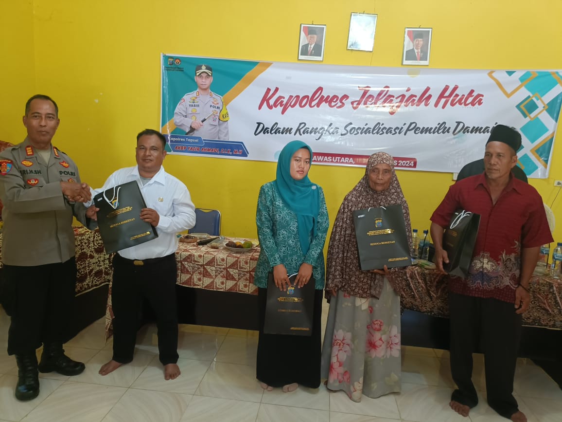 Kasi Propam Polres Tapsel, AKP R Triharjanto, saat menyerahkan souvenir ke perwakilan masyarakat di sela gerakan Kapolres Jelajah Huta