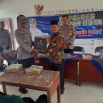 Kasat Binmas Polres Tapsel, AKP Eka Wahyudi, didampingi Ka SPKT, Ipda Irwan Sarumpaet, saat menyerahkan souvenir ke perwakilan perangkat Desa Aek Simanat yang hadir dalam gerakan Kapolres Jelajah Huta