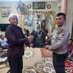 Kasat Tahti Polres Tapsel, Iptu Asjul Pane, saat menyerahkan souvenir ke masyarakat di sela gerakan Kapolres Jelajah Huta