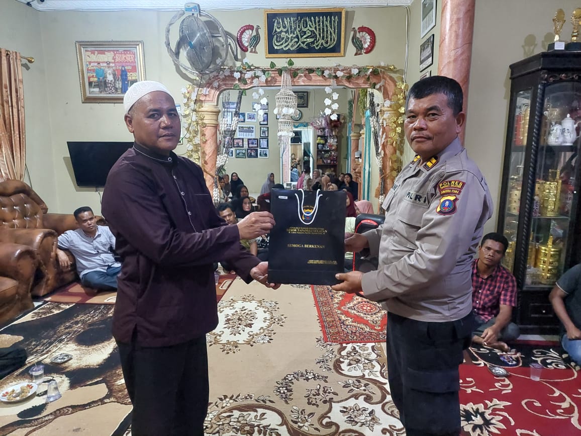 Kasat Tahti Polres Tapsel, Iptu Asjul Pane, saat menyerahkan souvenir ke masyarakat di sela gerakan Kapolres Jelajah Huta