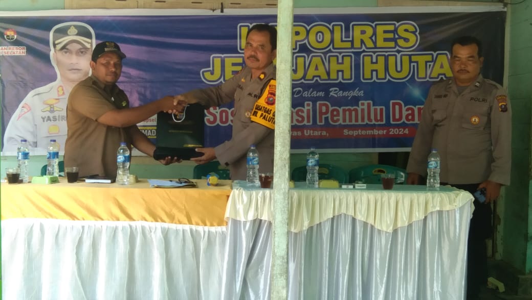 Kabag SDM Polres Tapsel, Kompol Sumanto Naibaho, saat menyerahkan souvenir ke perwakilan masyarakat di sela gerakan Kapolres Jelajah Huta