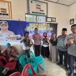 Kasiwas Polres Tapsel, AKP Ismaya, didampingi Kanit Tipikor, Ipda Saad Mardian Harahap, usai berikan souvenir ke perwakilan masyarakat di sela gerakan Kapolres Jelajah Huta