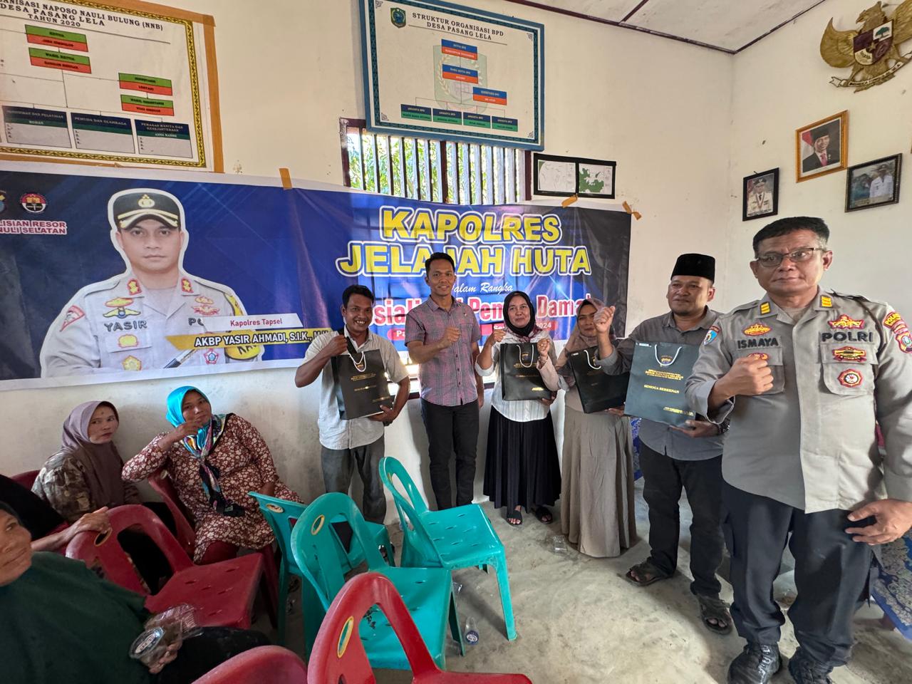 Kasiwas Polres Tapsel, AKP Ismaya, didampingi Kanit Tipikor, Ipda Saad Mardian Harahap, usai berikan souvenir ke perwakilan masyarakat di sela gerakan Kapolres Jelajah Huta