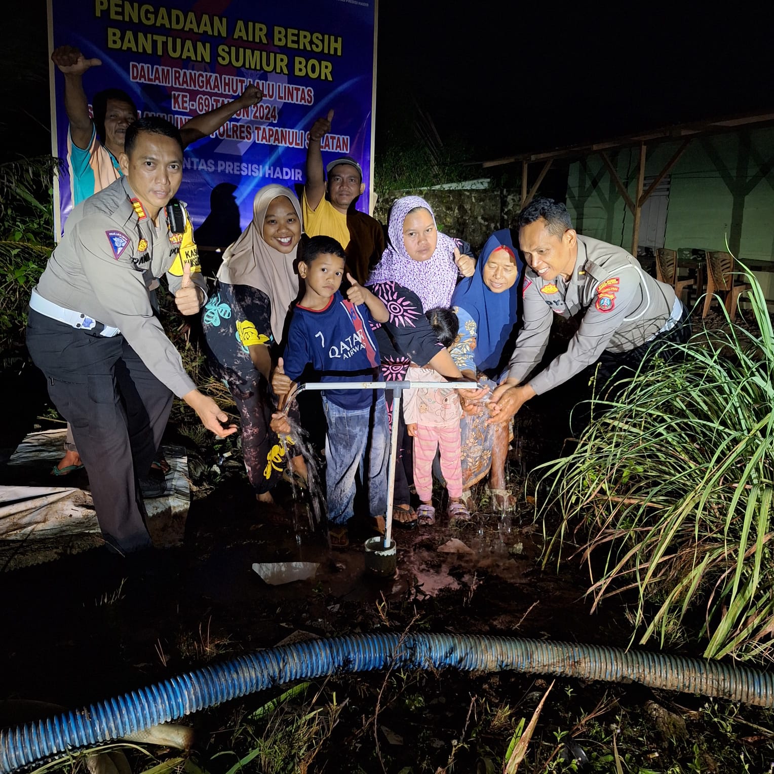 Kasat Lantas Polres Tapsel, AKP Danil Saragih, didampingi Kanit Regident, Ipda Edy Sofyan Nasution, bersama masyarakat Kelurahan Pargarutan yang kegirangan saat menikmati air bersih yang pertama kali muncul dari sumur bor yang dibangun Sat Lantas dalam rangka memperingati HUT Polantas ke-69