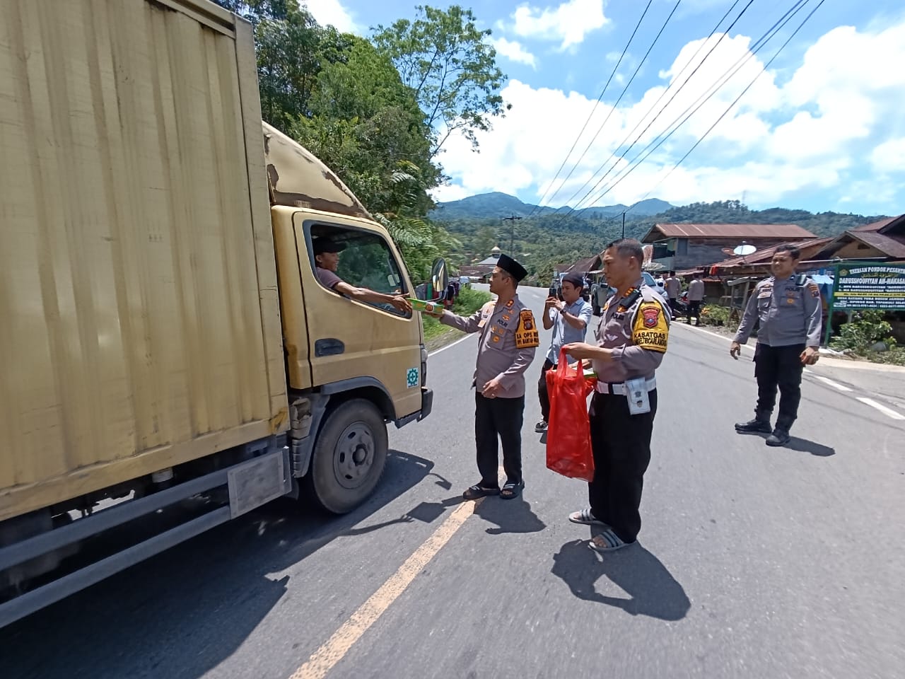 Kapolres Tapsel, AKBP Yasir Ahmadi, didampingi Kasat Lantas, AKP Danil Saragih, dan lainnya saat turun ke jalan guna berbagi ratusan nasi kotak ke pengendara yang melintas di sekitar Desa Situmba Sidangkal, Kecamatan Sipirok