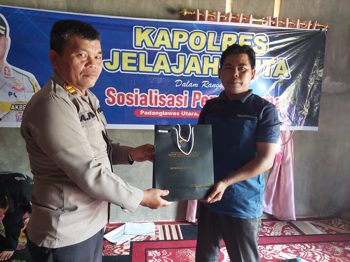 Kasat Tahti Polres Tapsel, Iptu Asjul Pane, saat menyerahkan souvenir ke perwakilan masyarakat di sela gerakan Kapolres Jelajah Huta