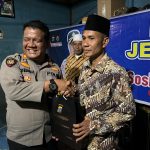 Kasat Samapta Polres Tapsel, AKP Tona Simanjuntak, saat menyerahkan souvenir ke perwakilan masyarakat di sela gerakan Kapolres Jelajah Huta