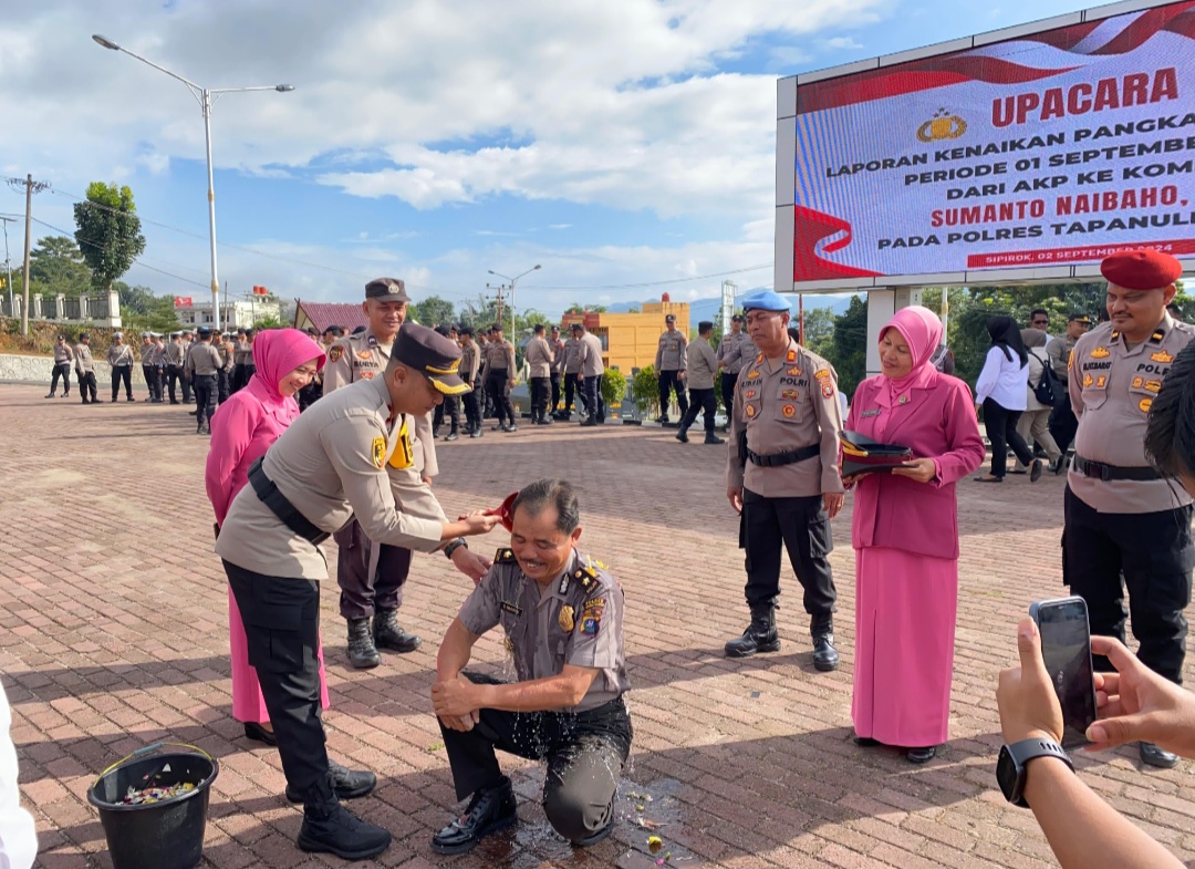 Kapolres Tapsel, AKBP Yasir Ahmadi, diwakili Waka Polres, Kompol Rapi Pinakri, saat menyirami air bunga setaman ke Kabag SDM, Kompol Sumanto Naibaho, yang naik pangkat dari AKP ke Kompol