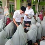 Calon Wakil Wali Kota Padangsidimpuan, Gempar Nauli Hamonangan Nasution, didampingi Tim Pemenangan, Indar Sakti Tanjung, membagikan cinderamata ke ibu-ibu jemaah Majelis Taklim Darun Najah