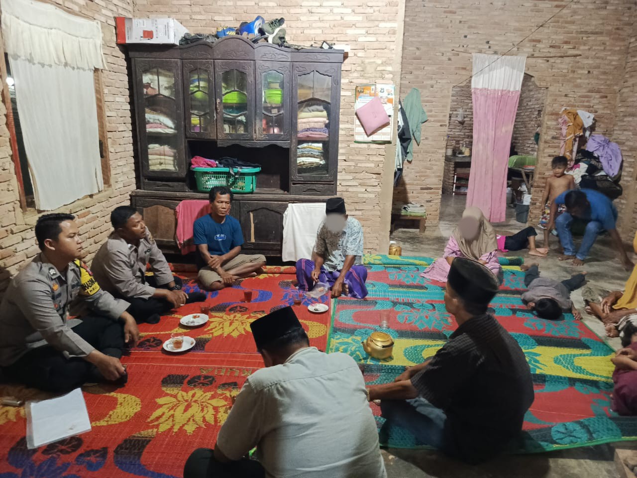 Personel Polsek Dolok bersama perangkat Desa Tanjung Longat, saat proses mediasi atas kasus dugaan KDRT yang terjadi pada pasangan suami istri