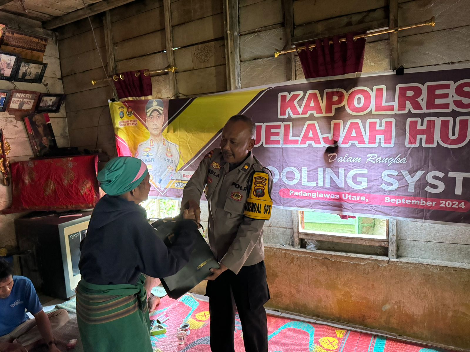 Kabag Ops Polres Tapsel, Kompol Abdi Abdillah, saat menyerahkan souvenir ke perwakilan masyarakat di sela gerakan Kapolres Jelajah Huta