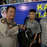 Kasat Samapta Polres Tapsel, AKP Tona Simanjuntak, saat menyerahkan souvenir kepada perwakilan masyarakat di sela gerakan Kapolres Jelajah Huta