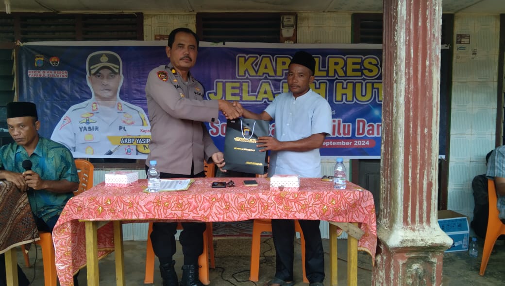 Kabag SDM Polres Tapsel, Kompol Sumanto Naibaho, saat menyerahkan souvenir usai gerakan Kapolres Jelajah Huta