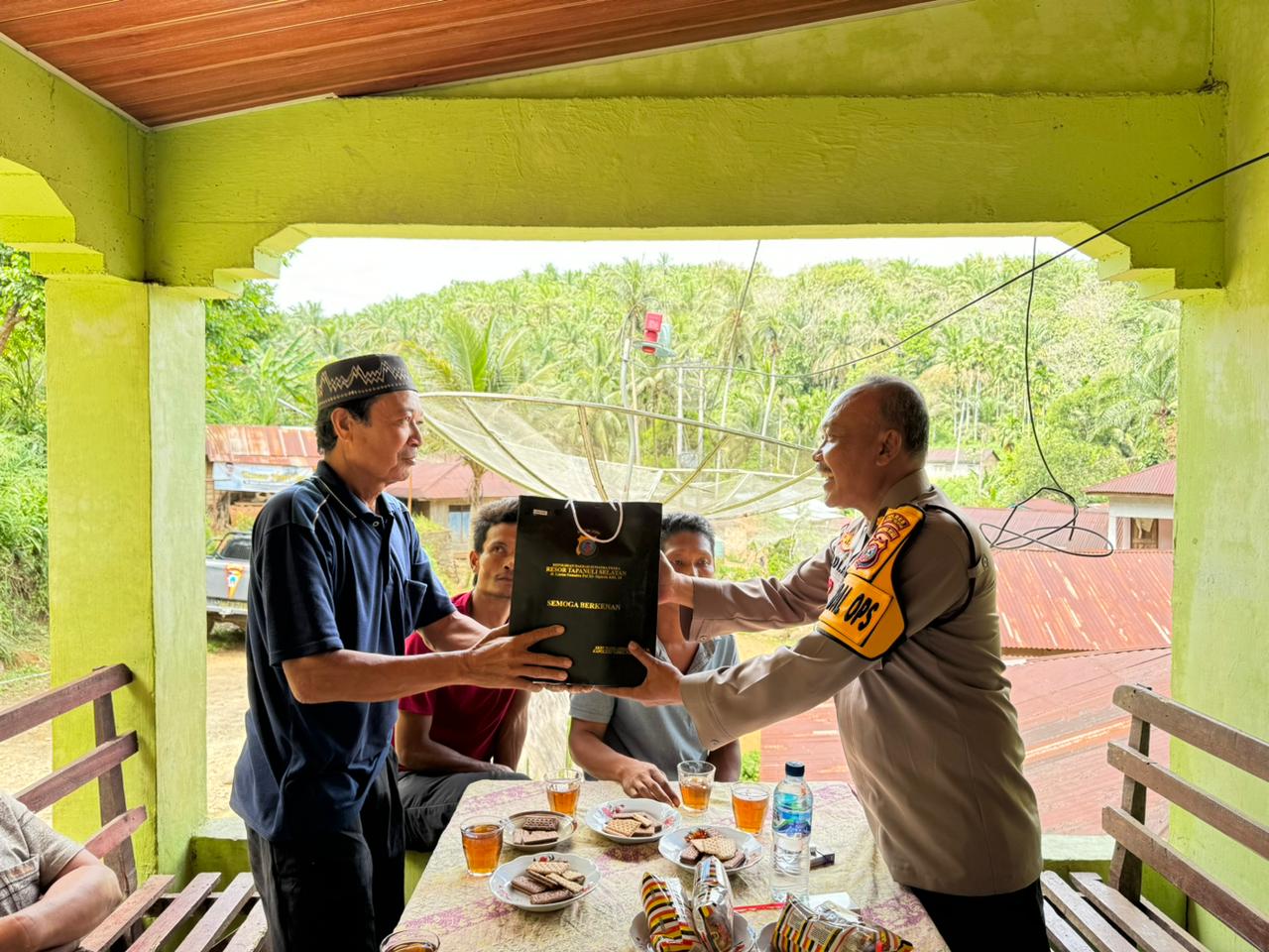 Kabag Ops Polres Tapsel, Kompol Abdi Abdillah, saat menyerahkan souvenir ke perwakilan masyarakat di sela gerakan Kapolres Jelajah Huta