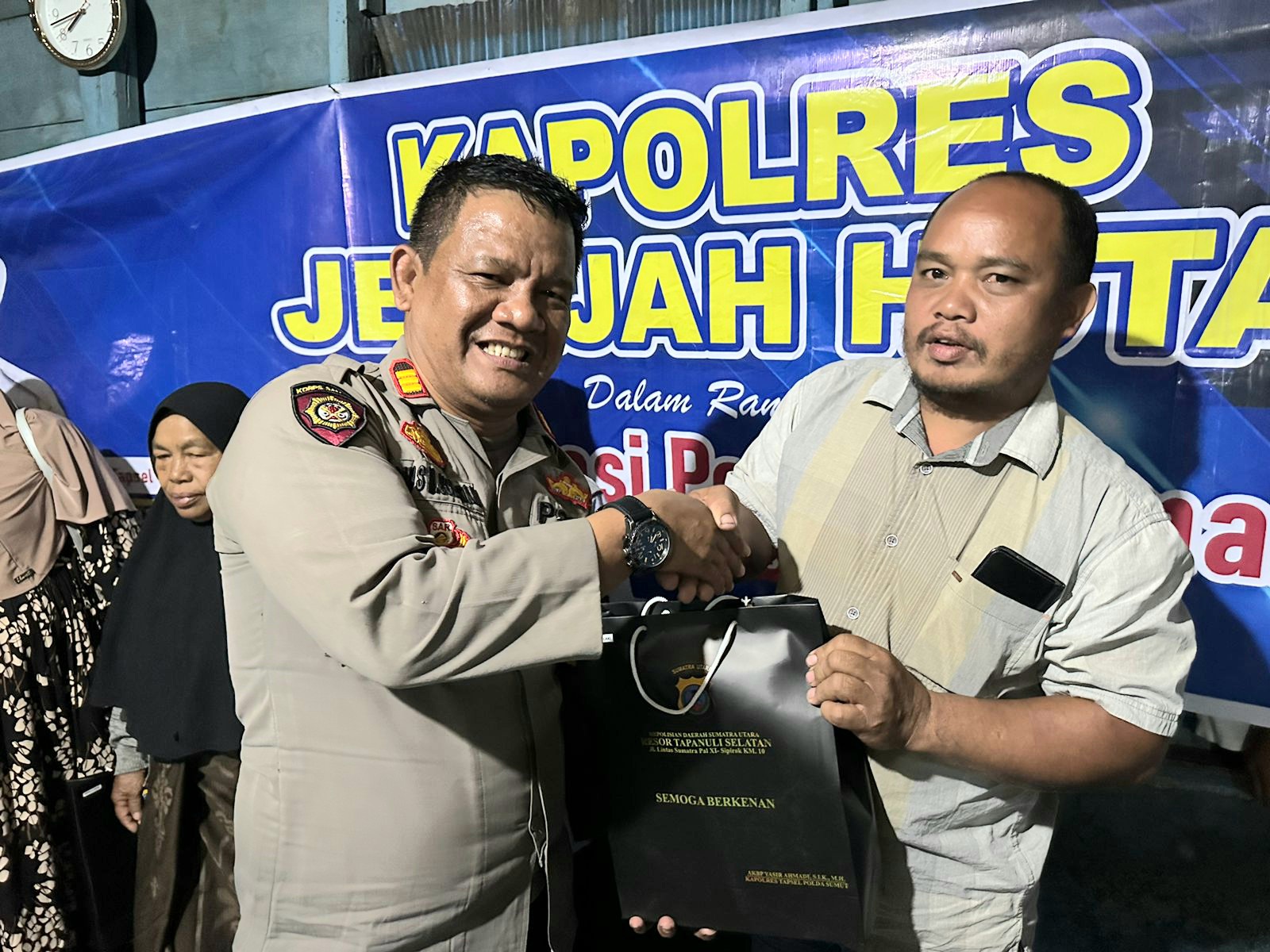 Kasat Samapta Polres Tapsel, AKP Tona Simanjuntak, masih terlihat sumringah saat menyerahkan souvenir kepada perwakilan masyarakat usai gerakan Kapolres Jelajah Huta