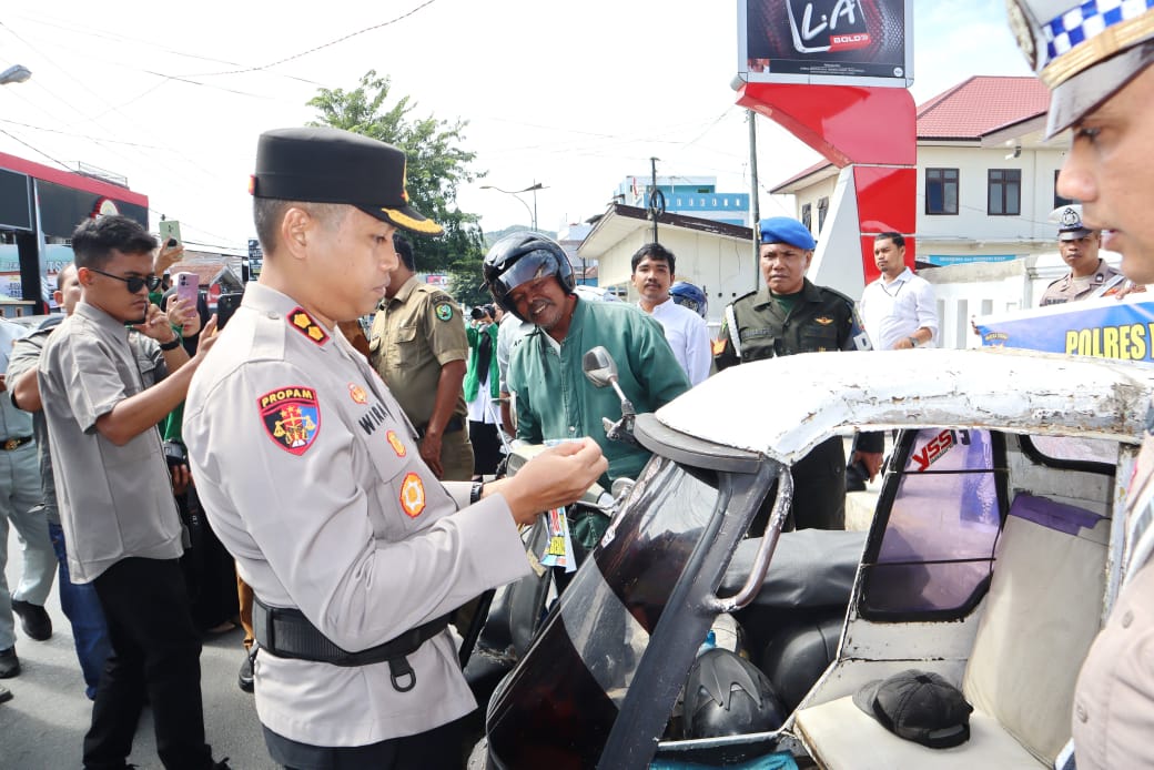 Kapolres Padangsidimpuan, AKBP Dr Wira Prayatna, saat menempel stiker ke becak bermotor yang berisi imbauan agar pengguna jalan tertib berlalulintas
