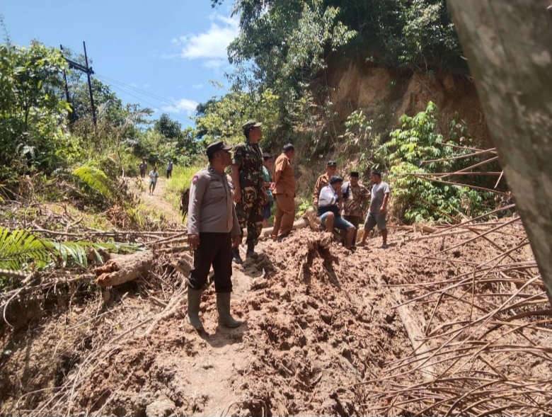 Bersama Babinsa dan masyarakat sekitar, personel Polsek SD Hole bergotongroyong bersihkan material longsor yang menimbun akses jalan penghubung antar dua Desa di Kecamatan Aek Bilah, Kabupaten Tapsel