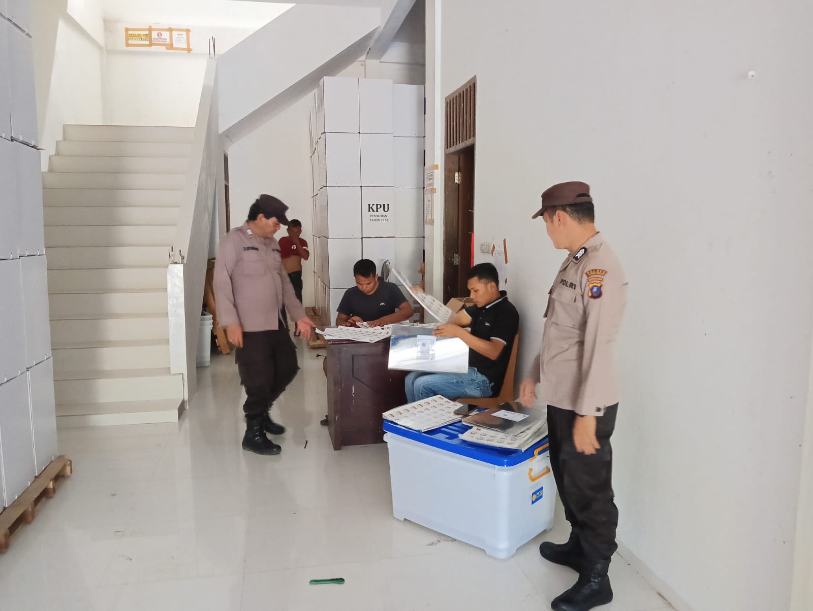 Dua orang personel Polres Tapsel dibantu petugas Keamanan Dalam (Kamdal) saat bertugas melakukan pengamanan di Gudang Logistik KPU Paluta