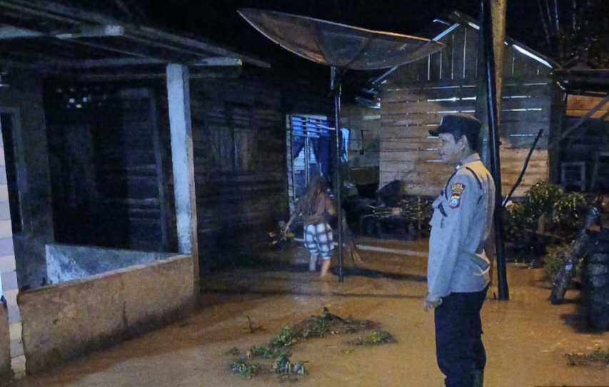 Personel Polsek Batang Angkola tampak memonitor langsung kondisi salah satu Rumah warga yang terlihat tergenang air akibat curah hujan deras yang melanda Desa Sitampa Simatoras