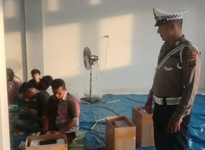 Personel Polsek Padang Bolak saat mengawal proses pelipatan dan penyortiran surat suara pemilihan Gubernur dan Wakil Gubernur Sumatera Utara di Gudang KPU Paluta