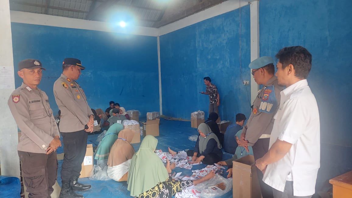 Kapolsek Sipirok, Iptu Aswin Manurung, saat memantau jalannya penyortiran dan pelipatan kertas surat suara di Gudang Logistik KPU Tapsel