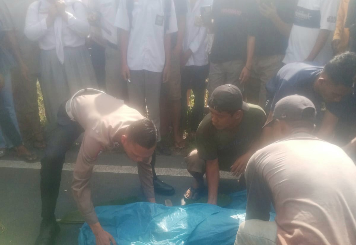 Petugas dari Unit Laka Sat Lantas Polres Tapsel saat mengevakuasi jenazah korban yang meninggal dunia di TKP usai ditabrak satu unit mobil Toyota Fortuner di Desa Holbung