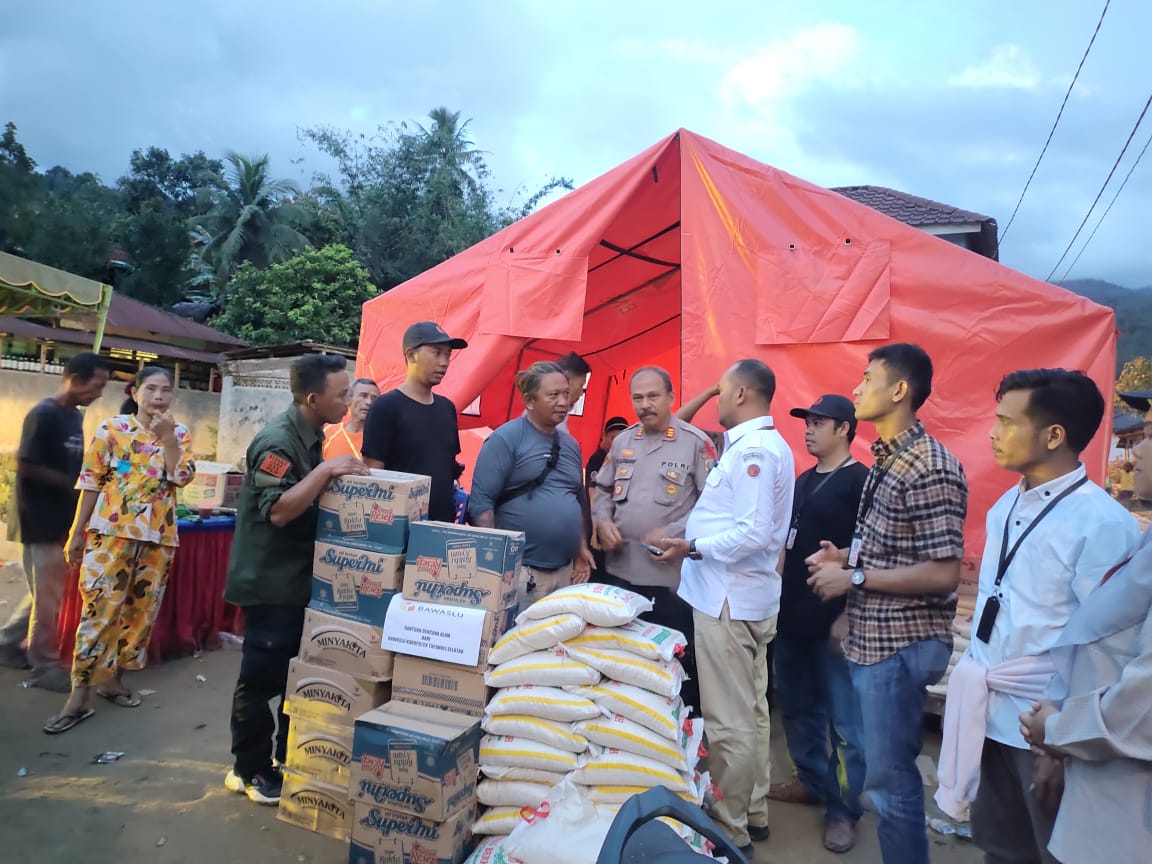 Kapolsek Batang Angkola, AKP Arma Ginda Harahap dan Ketua Bawaslu Tapsel, Taufik Hidayat, saat salurkan bantuan berupa bahan makanan pokoke ke korban terdampak banjir bandang