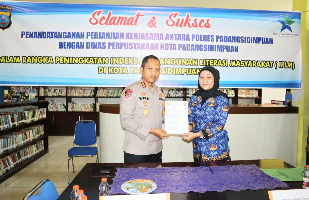 Kapolres Padangsidimpuan, AKBP Dr Wira Prayatna bersama Kepala Dinas Perpustakaan, Efrida Zulyanti Nasution, menunjukkan MoU terkait peningkatan minat baca di masyarakat