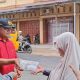 Calon Wali Kota No.03, Dr Hapendi Harahap, didampingi Sekretaris Tim Pemenangan, Saripah Hanum Lubis, saat berbagi nasi berkah ke masyarakat Padangsidimpuan