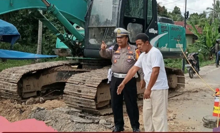 Kasat Lantas Polres Palas, AKP Tongan Siregar, saat memberi imbauan di lokasi perbaikan Jalan/Jembatan yang rusak di Desa Bulusonik