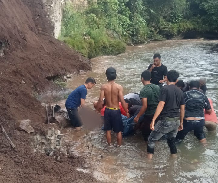 TNI, Polri, dan masyarakat sekitar, saat berupaya mengevakuasi jenazah korban yang tertimbun material longsor dek penahan tanah di tepi Sungai