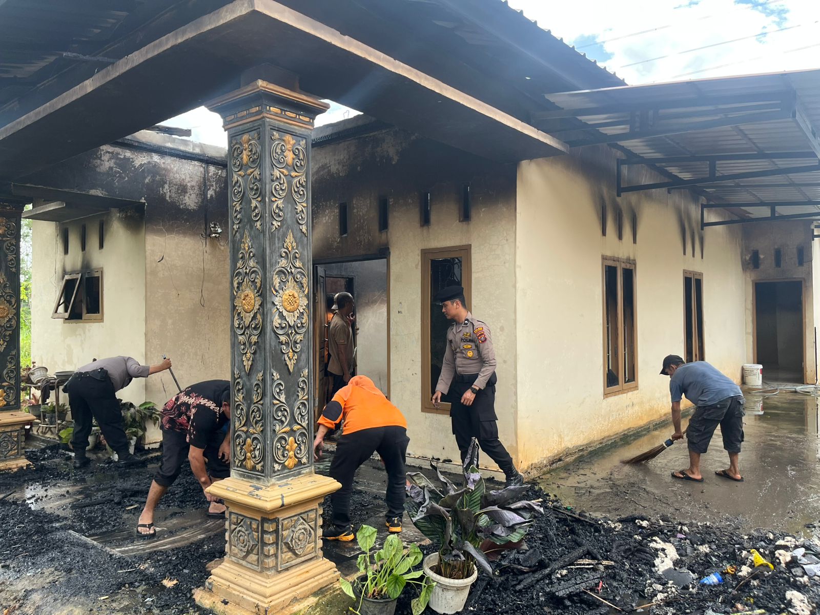 Personel Polres Padangsidimpuan dan lainnya saat membantu membersihkan Rumah dari puing ataupun sisa material kebakaran