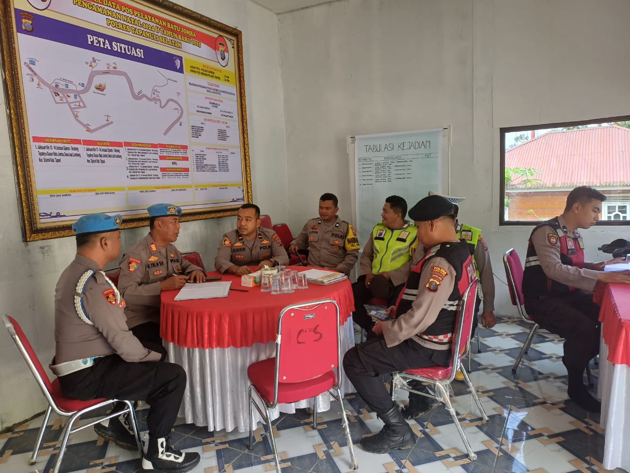 Kasi Propam Polres Tapsel, AKP R Triharjanto, saat berbincang dengan Kanit Reskrim Polsek Sipirok, Ipda Ahmad Juli Nasution, dan anggota lainnya di Pos Yan Batu Jomba