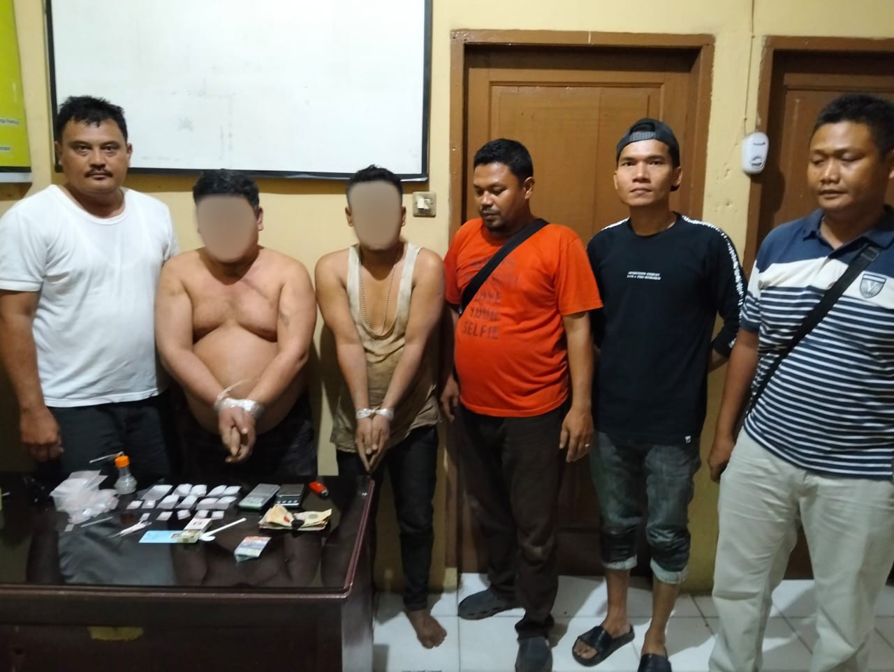 Kedua pria berinisial, LSR dan IH berikut barang bukti narkotika jenis sabu usai diamankan Kanit Reskrim Polsek Dolok, Ipda Maraden Hutabarat (paling kiri), bersama Tim Opsnal