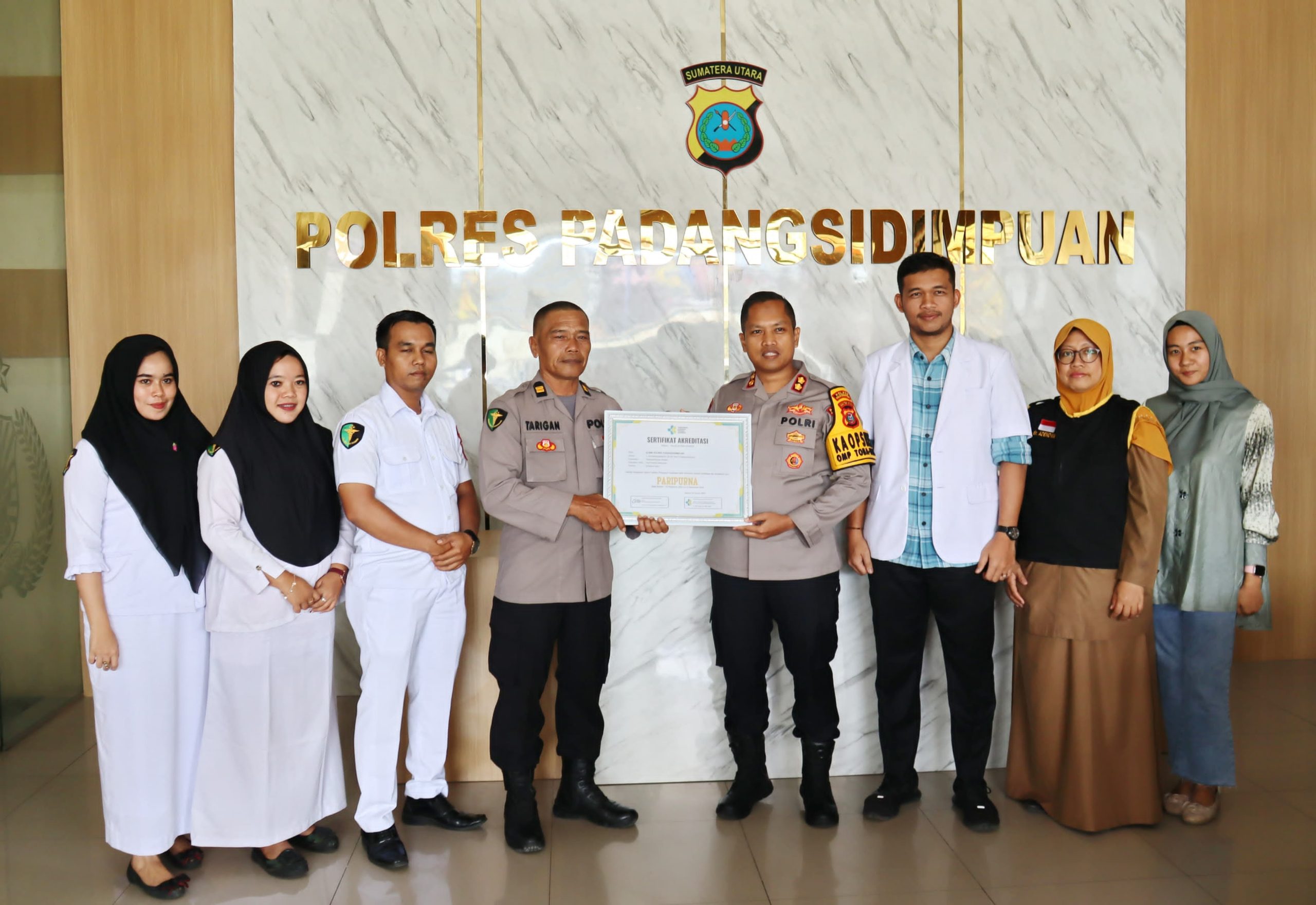 Kapolres Padangsidimpuan, AKBP Dr Wira Prayatna, didampingi Kasi Dokkes, Iptu Endi Tarigan, menerima Sertifikat KAKP berupa akreditasi Paripurna pada Klinik Polres Padangsidimpuan
