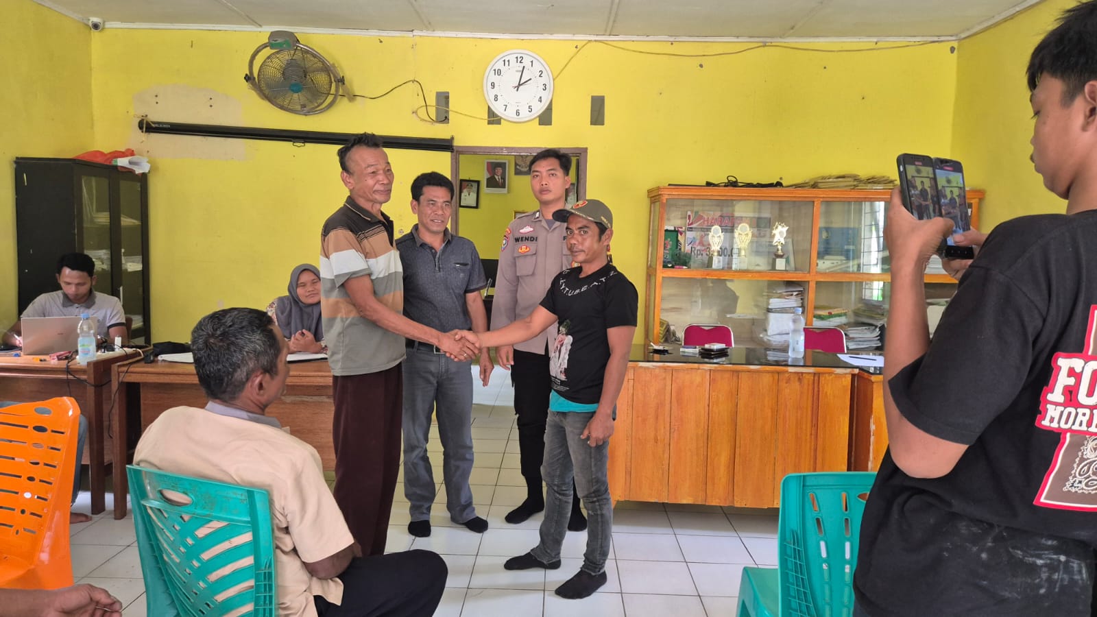 Kedua belah pihak saling bersalam-salaman usai mendapat problem solving dari Bhabinkamtibmas Polsek Batang Toru, Brigpol Wendi Pramono, dan perangkat Desa lainnya