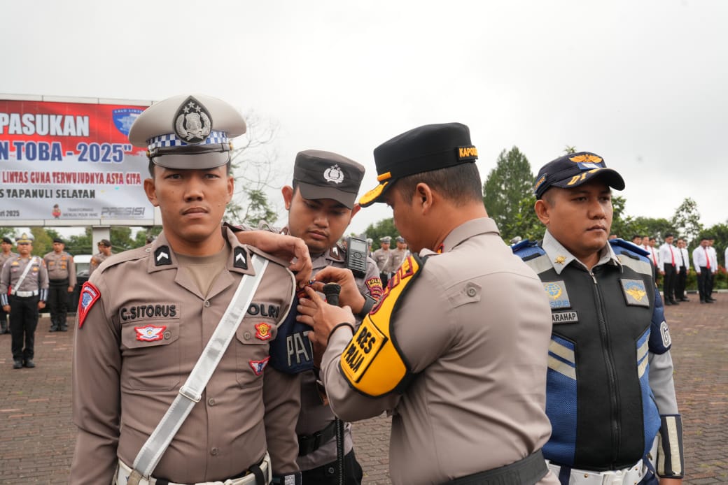 Kapolres Tapsel, AKBP Yasir Ahmadi, saat menyematkan pita Operasi Keselamatan Toba 2025 secara simbolis ke personel yang terlibat dalam tugas tersebut