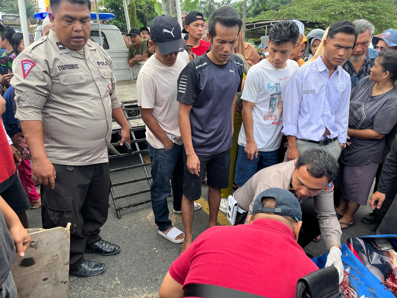 Polisi bersama warga saat proses evakuasi korban kecelakaan maut yang meninggal dunia di TKP
