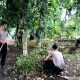 Para personel Polisi dari Polres Padangsidimpuan saat bergotongroyong membersihkan areal pemakaman di TPU