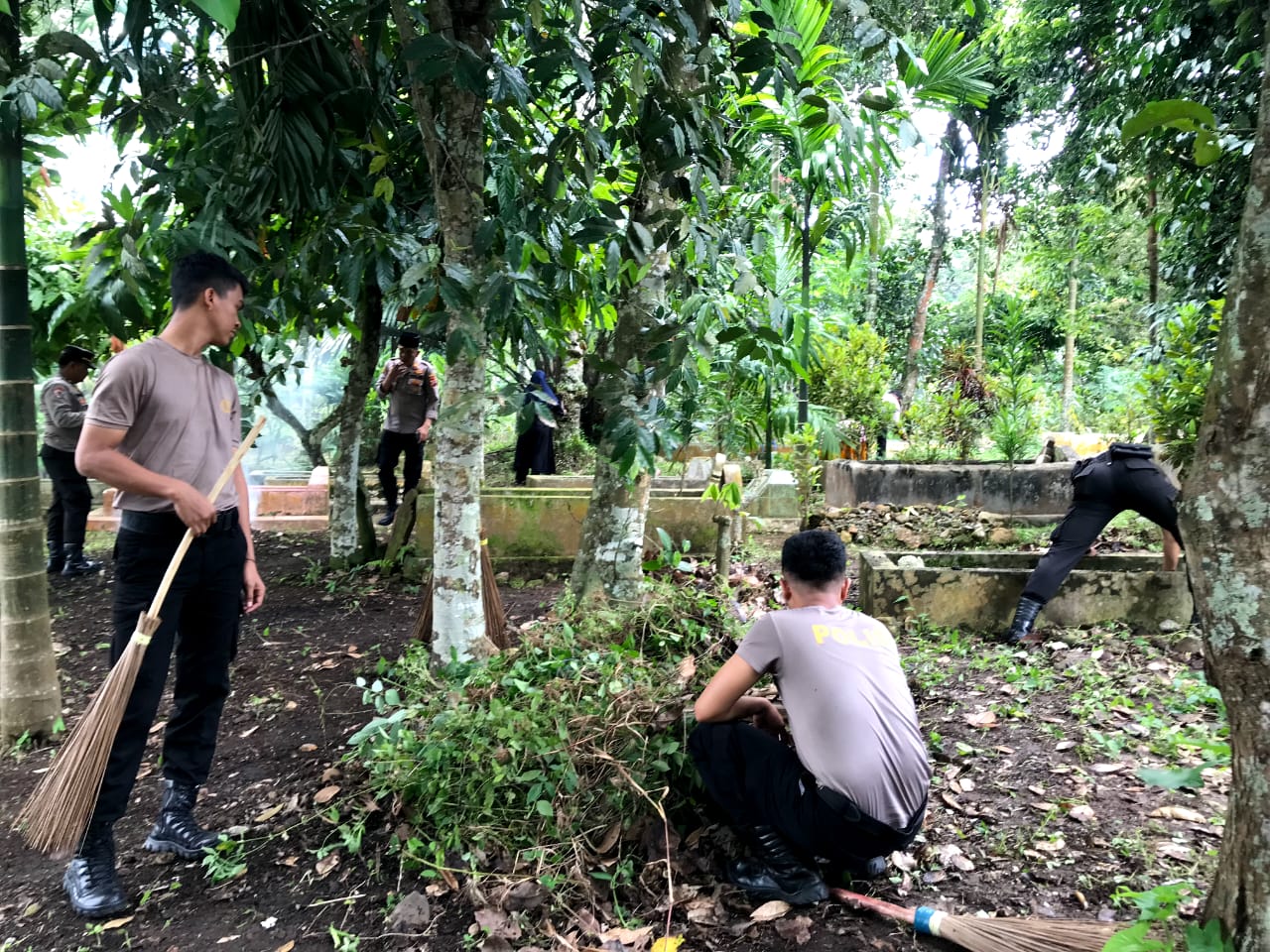 Para personel Polisi dari Polres Padangsidimpuan saat bergotongroyong membersihkan areal pemakaman di TPU