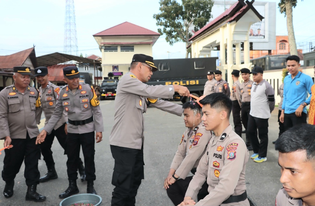 Kabag Ren Polres Padangsidimpuan, Kompol Zulkarnain, menyirami air bunga sebagai tradisi penyambutan dan penerimaan Bintara remaja Polri