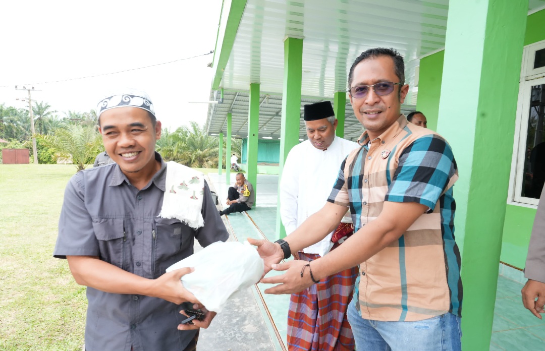 Kasat Reskrim Polres Tapsel, Iptu Agus Purnomo, saat membagikan nasi kotak kepada jamaah Masjid Emplasmen PT Tapian Nadenggan, usai melaksanakan salat Jumat berjamaah