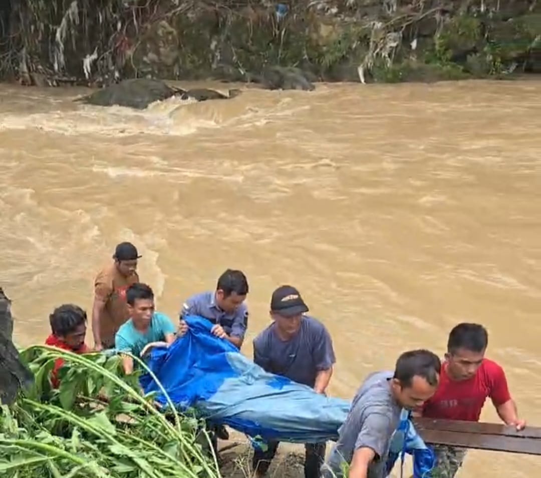 Sejumlah warga Desa Pudun Jae mengevakuasi korban, Feri Siregar, yang ditemukan meninggal dunia dalam keadaan tersangkut di sekitaran aliran Sungai Batang Angkola