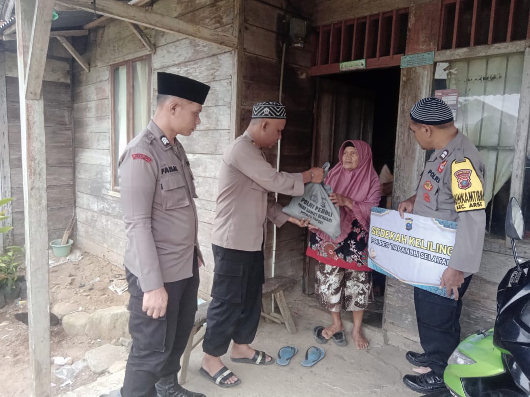 Plt Kasat Binmas Polres Tapsel, Iptu Taufik Manullang, saat menyerahkan uang santunan tali asih berikut paket sembako ke salah seorang Lansia