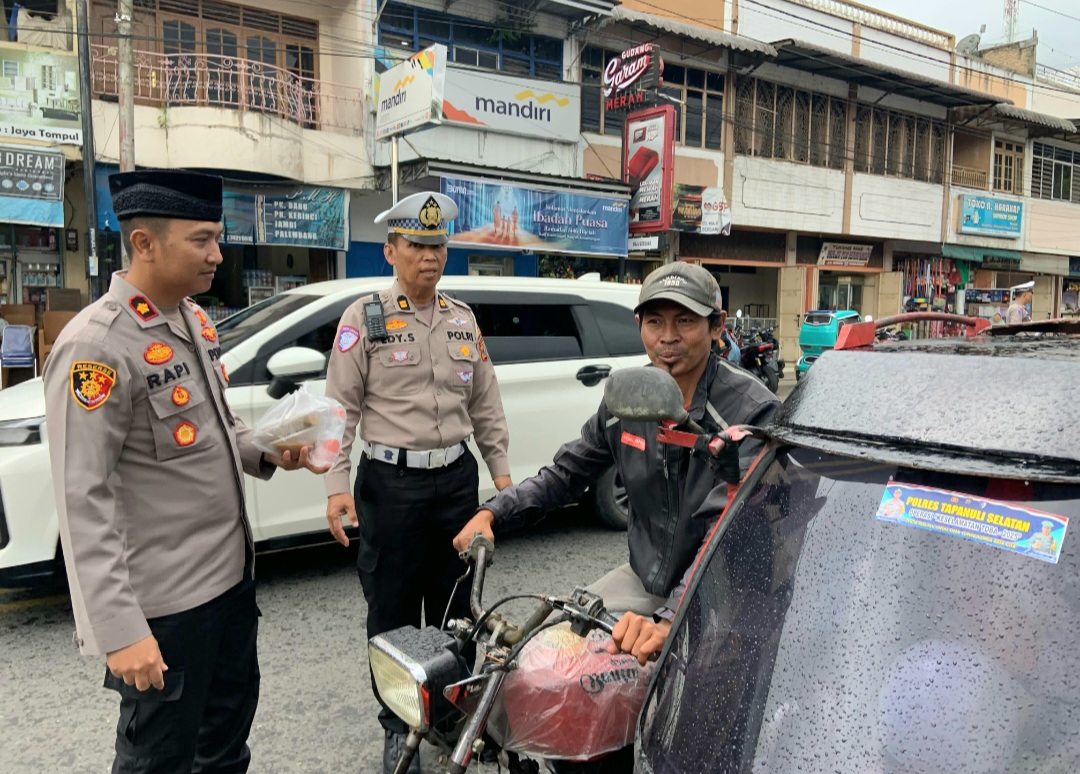 Waka Polres Tapsel, Kompol Rapi Pinakri, didampingi Kanit Regident, Iptu Edy Sofyan Nasution, saat membagikan takjil ke masyarakat