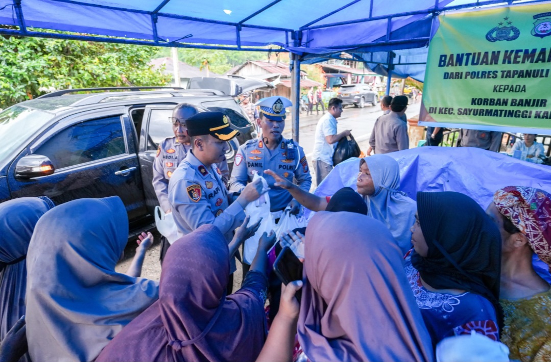 Waka Polres Tapsel, Kompol Rapi Pinakri, didampingi Kabag SDM, Kompol Abdi Abdillah, Kasat Lantas, AKP Danil Saragih, dan lainnya saat membagikan takjil serta nasi kotak ke korban terdampak banjir maupun pengguna jalan yang melintas di Desa Silaiya