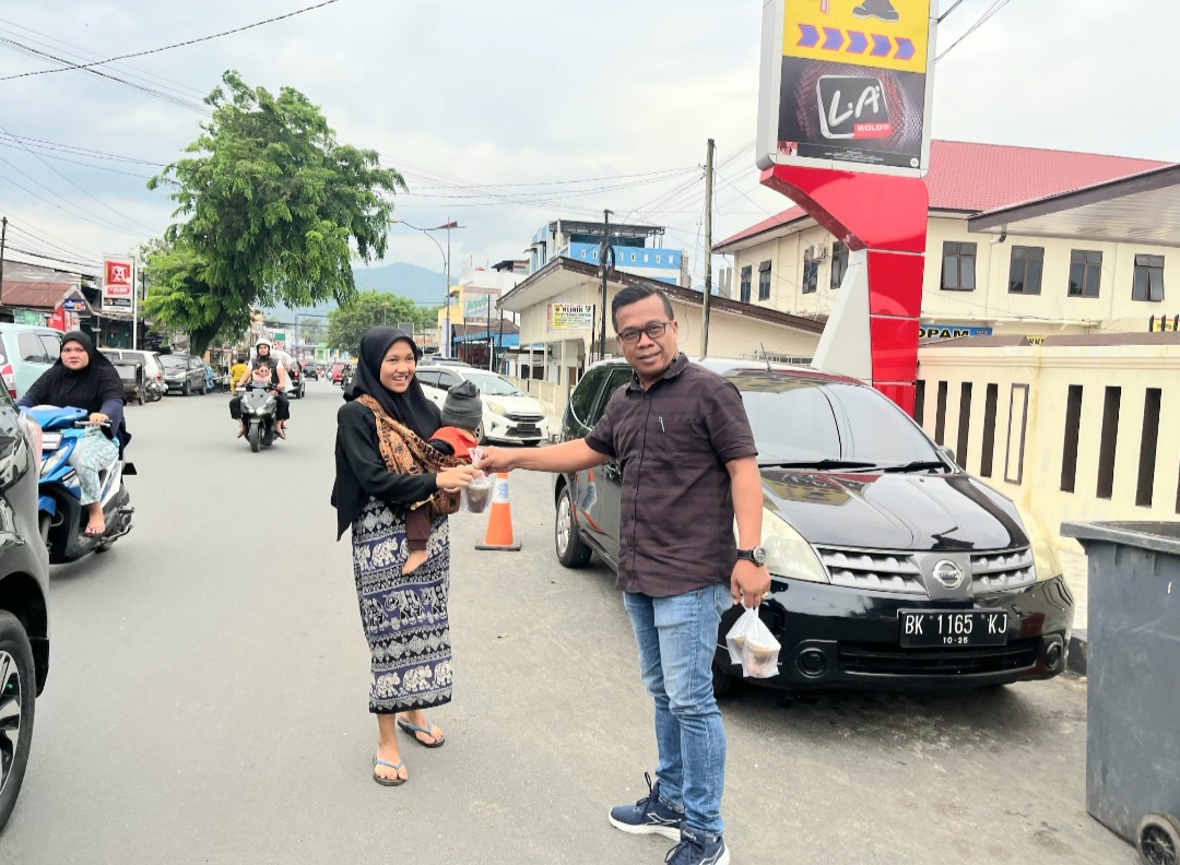 Kasat Intelkam Polres Padangsidimpuan, AKP Marzuki, saat membagikan takjil ke pejalan kaki yang melintas