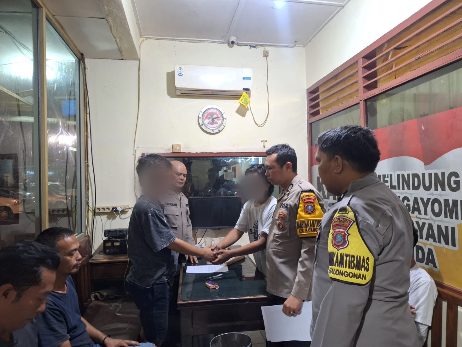 Kedua belah pihak saling bersalaman sebagai tanda telah terjadinya kesepakatan damai dalam kasus dugaan pemukulan yang disaksikan personel Polsek Batang Toru